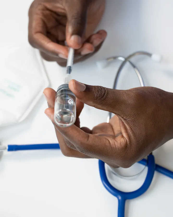 Healthcare worker placing a stethoscope on a patient's hand